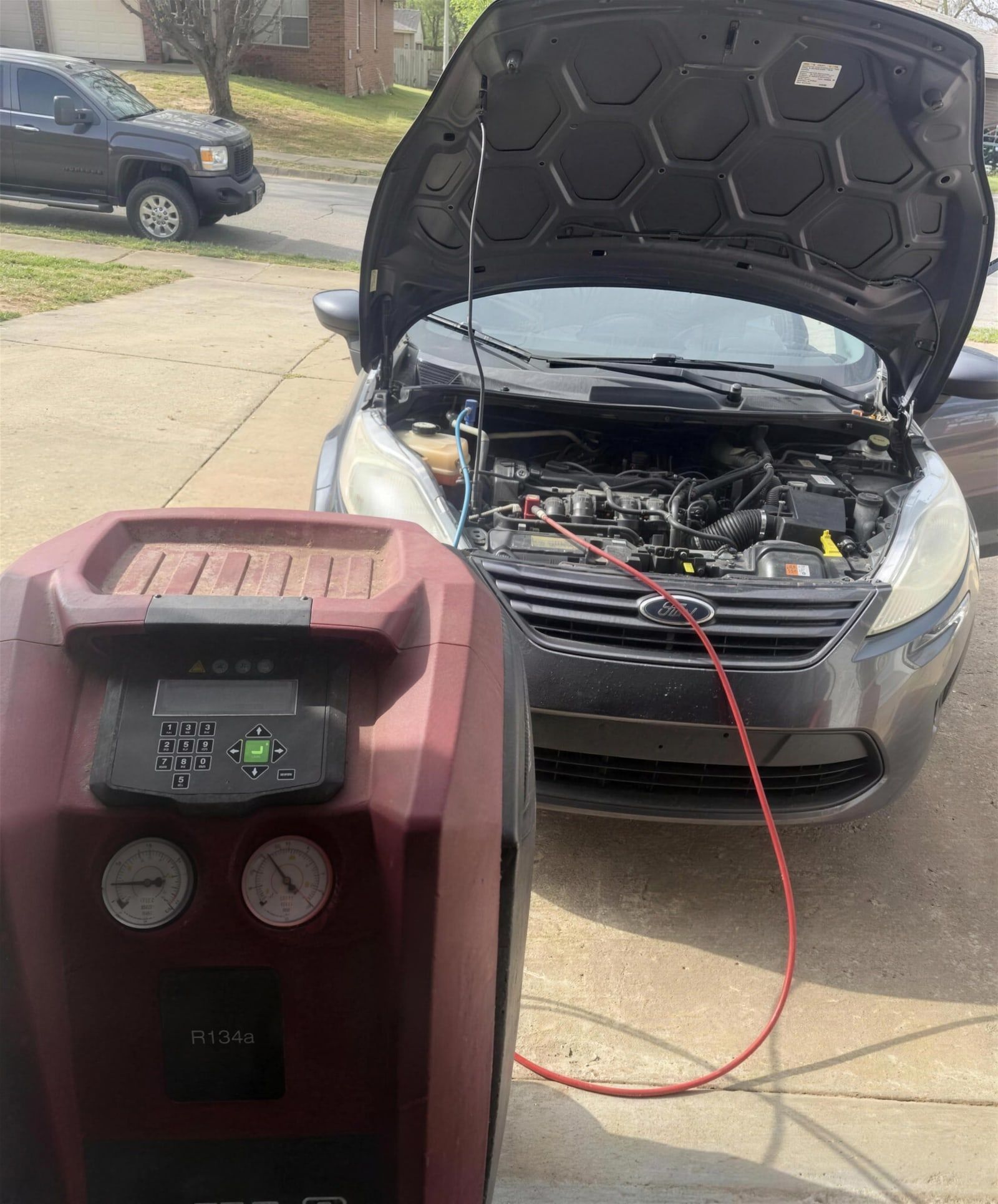 Mobile car A/C diagnostic and refrigerant service by H & H Auto LLC in a Northwest Arkansas driveway
